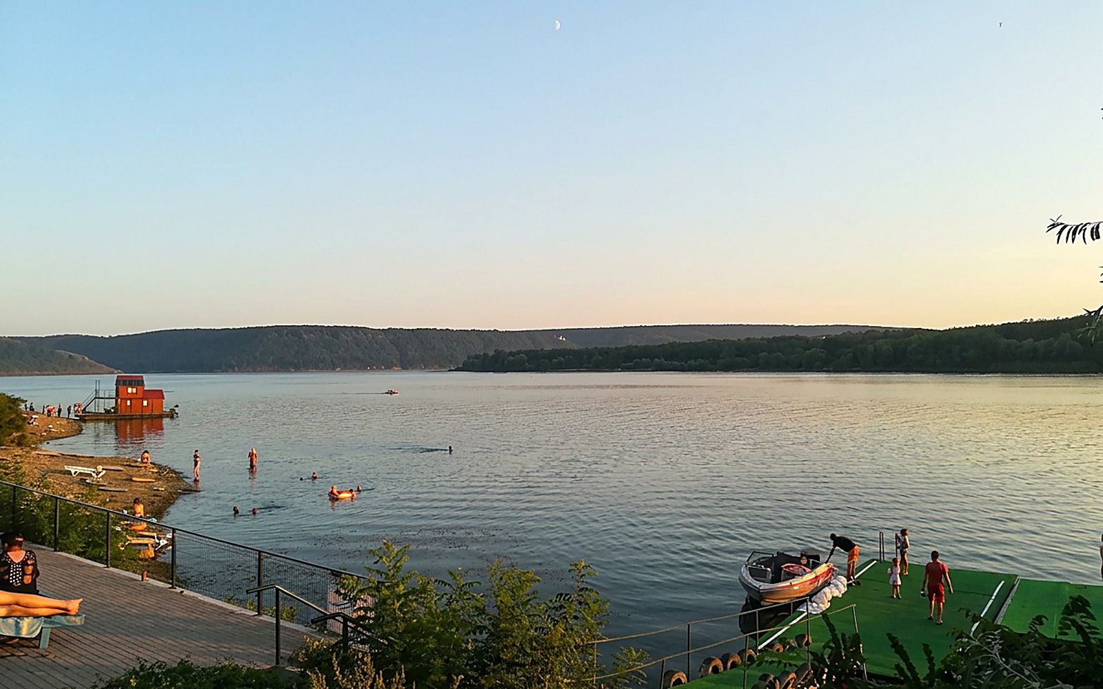 Пляж бази відпочинку на Дністрі: відпочивальники у воді, катер біля причалу